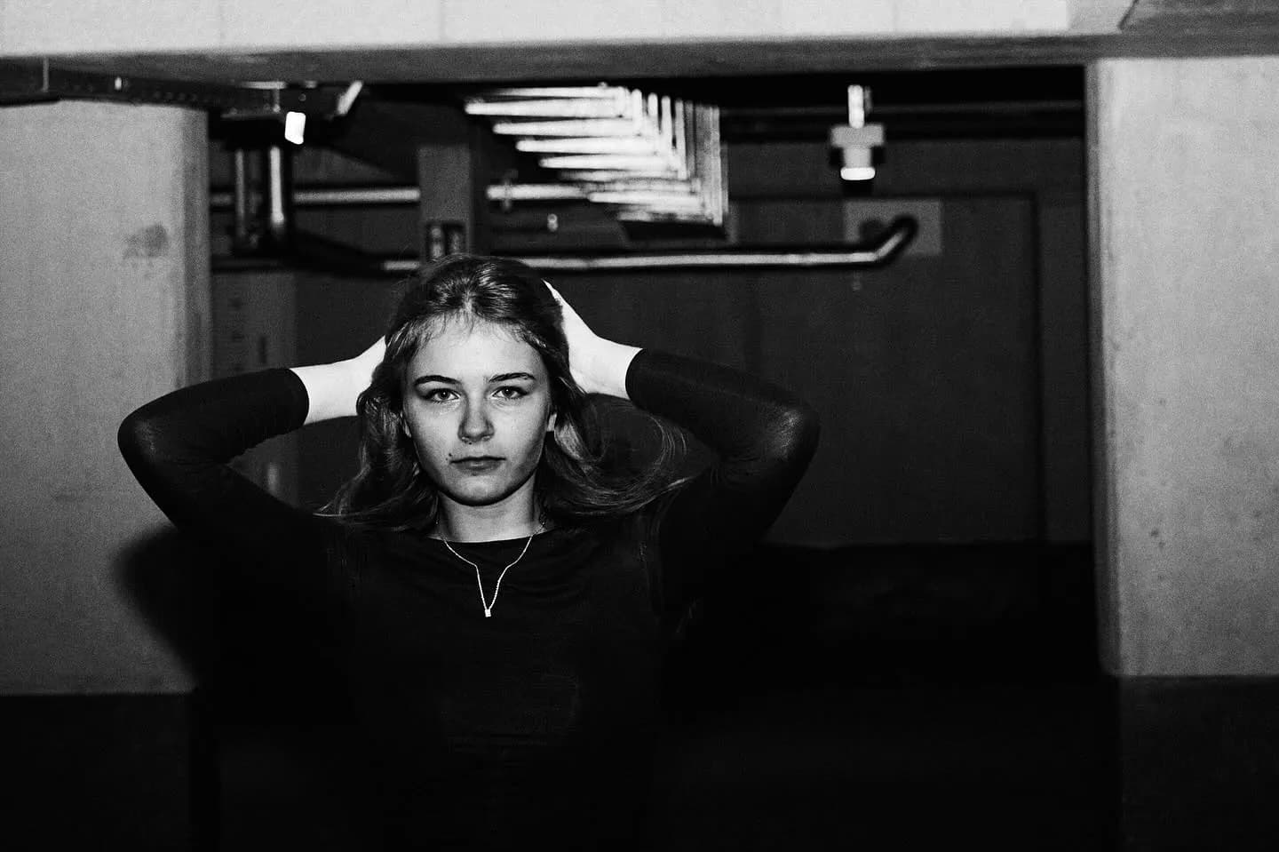 Kate Ushakova on a shoot, lit from above in a backstage corridor